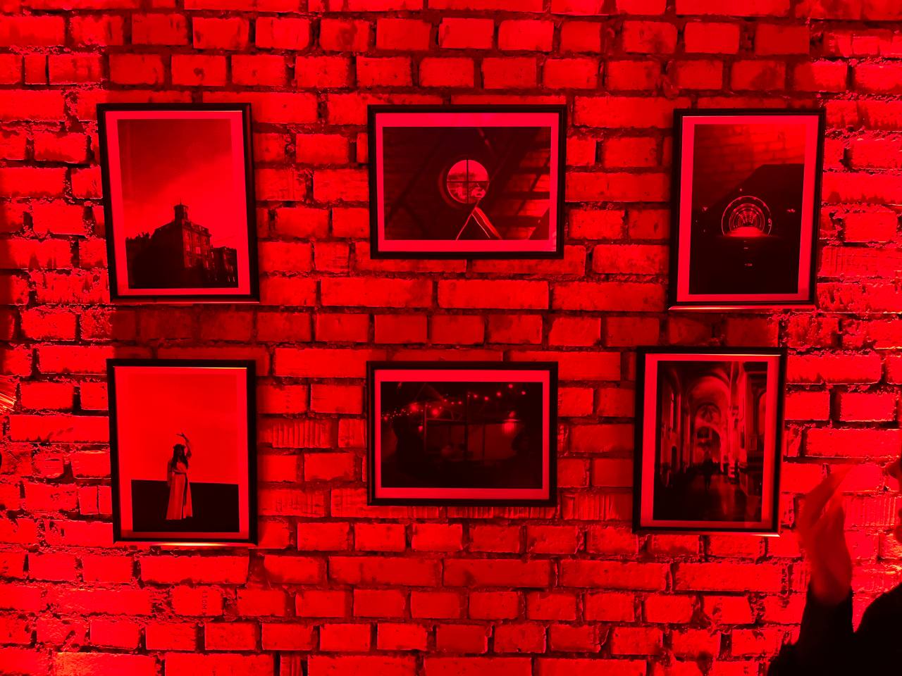 Фотографии на кирпичной стене в красных тонах.
